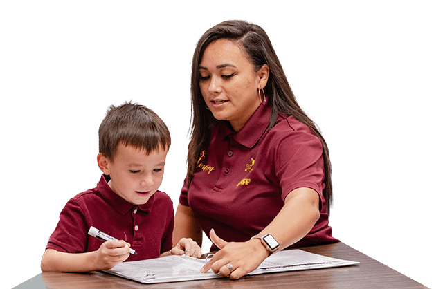Elementary student and teacher writing in a workbook