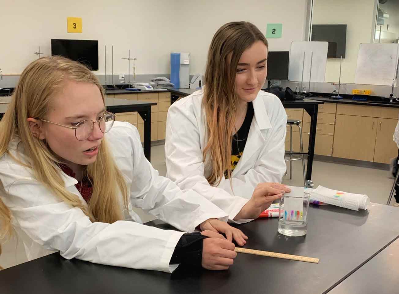Dos estudiantes de secundaria haciendo un experimento científico.